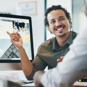 Can you see what Im referring to. Shot of two young businessmen having a discussion in an office.