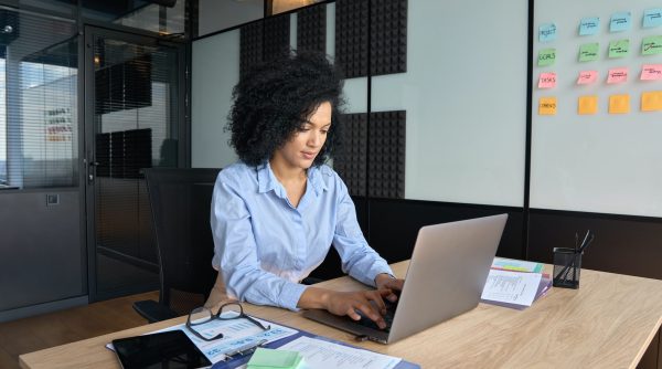 Concentrated African American businesswoman working typing using pc laptop.