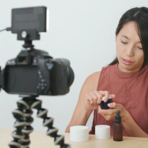 Woman taking video for beauty product at home