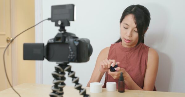 Woman taking video for beauty product at home